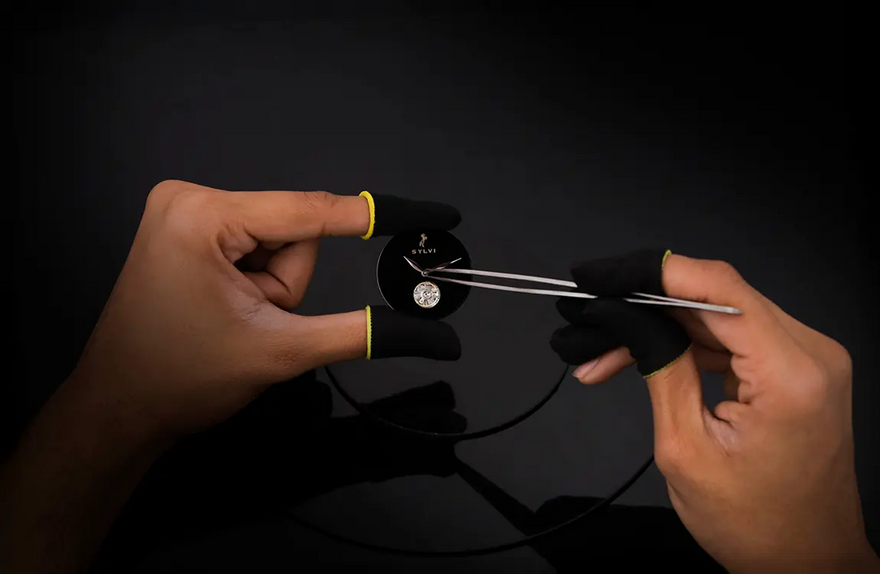 Person using a tool to adjust a watch on a dark background